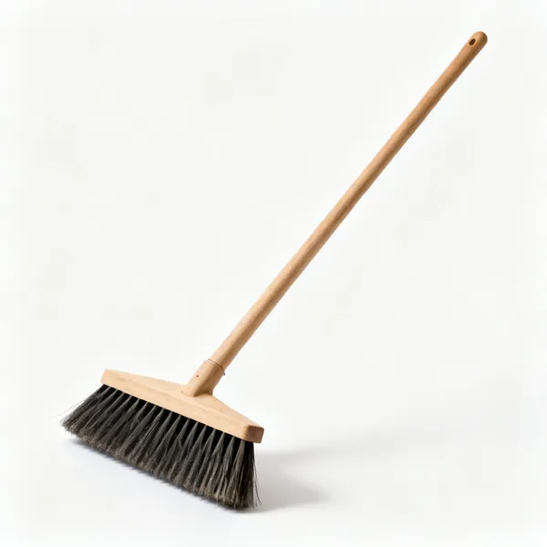 A stiff bristled yard broom with a wooden handle