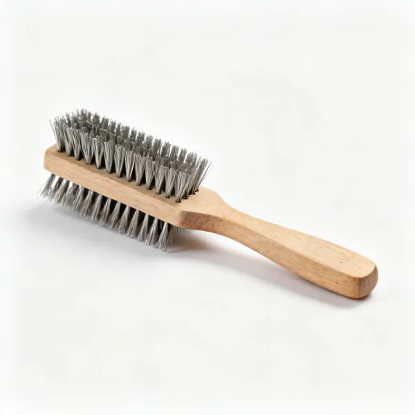 A hand wire brush with rows of stiff steel bristles and a wooden handle