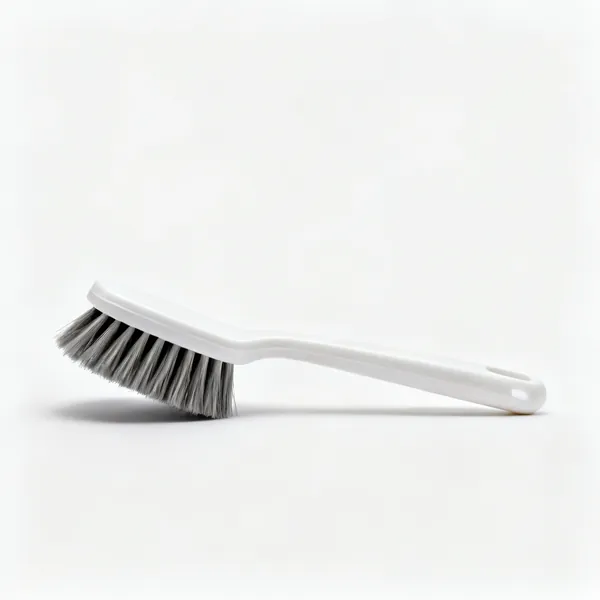A dish brush with stiff bristles and a plastic handle