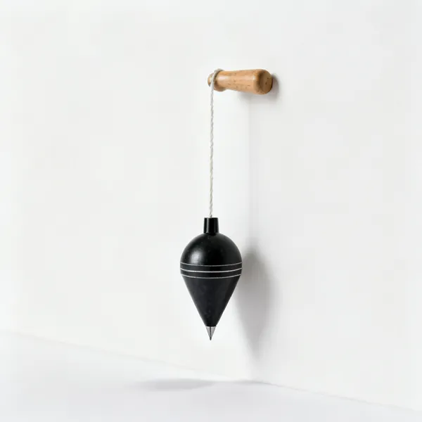 Plumb line: A plumb bob on a string against a wall