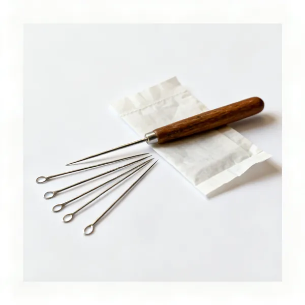 Crewel needles: Several crewel embroidery needles with long eyes beside a paper packet